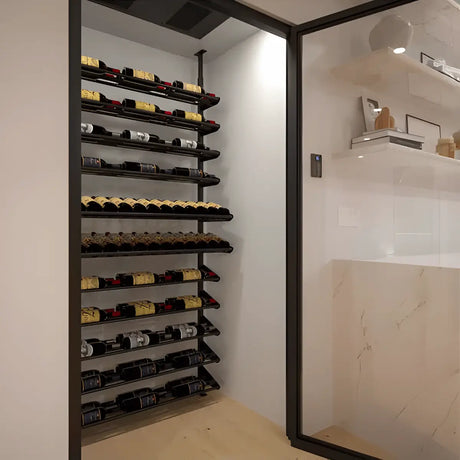 Modern glass-enclosed wine showcase with angled metal racks displaying bottles in clean, label-forward rows for a sleek wine display.