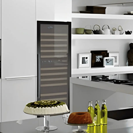 Tall built-in wine fridge with glass door and wooden shelves storing 100–199 bottles, integrated into a modern white kitchen setting.